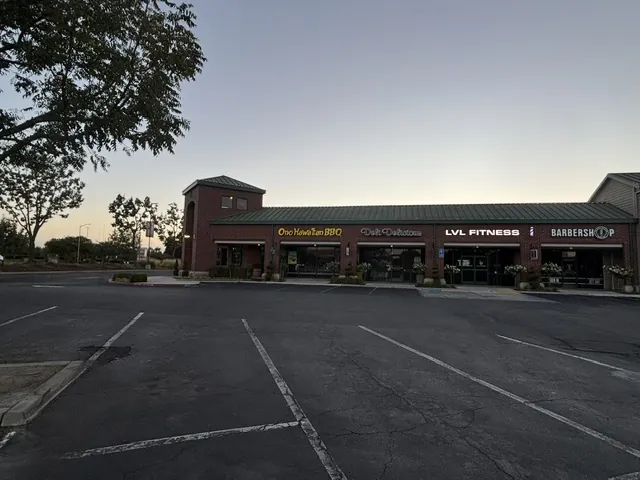 Trading Post retail center in Clovis, CA, with a row of shop storefronts under a green metal roof